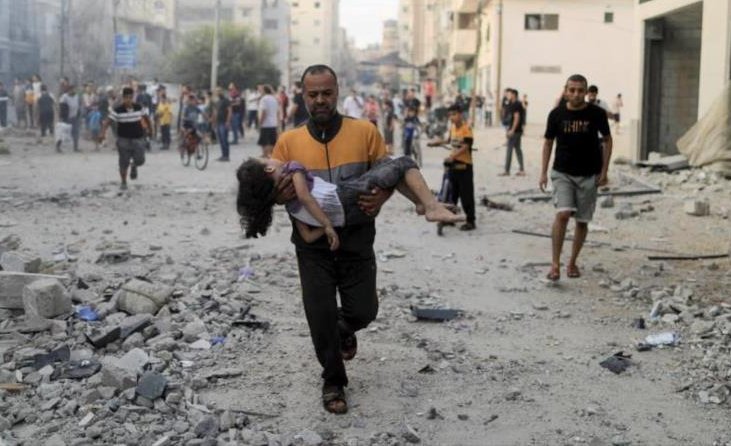 Palestino carga a un infante herido luego de un bombardeo israelí