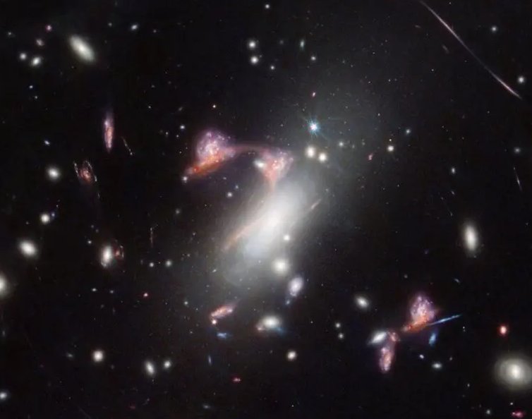 La imagen revela la interacción entre una galaxia espiral y una galaxia roja polvorienta, ambas distorsionadas de manera extraordinaria por el cúmulo de galaxias conocido como MACS-J0417.5-1154