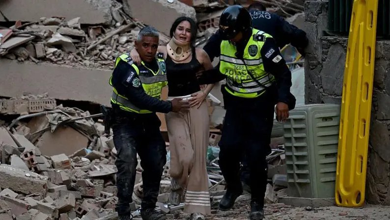 Policías socorren a una mujer entre los escombros de un edificio derrumbado en Caracas.