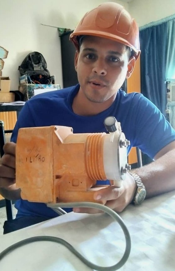 El ingeniero Industrial Eneas González Ondarza exhibe con orgullo una dosificadora de la planta de ósmosis, luego del desarme minucioso de la bobina.