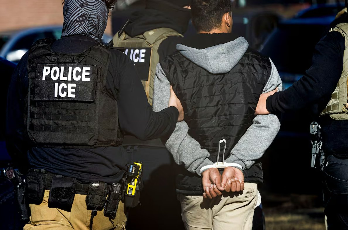 Agentes del Servicio de Inmigración y Control de Aduanas detienen a un hombre tras una redada en un complejo de apartamentos en Denver, Colorado.