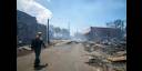 Hombre pasa junto a restos de un incendio forestal en Lahaina