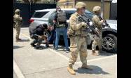 Miembros de la Guardia Nacional custodian a agentes del Servicio de Inmigración y Control de Aduanas
