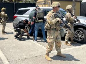 Miembros de la Guardia Nacional custodian a agentes del Servicio de Inmigración y Control de Aduanas