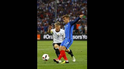 Griezmann disputa un balón con Bastian Schweinsteiger