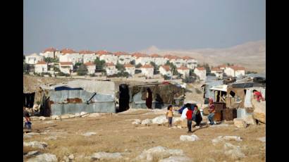Para propiciar el crecimiento de los asentamientos judíos (al fondo) la población palestina es continuamente desalojada
