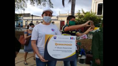 La directora provincial de Salud, Ailuj Casanova Barreto, recibe un reconocimiento a nombre de todos los trabajadores del sector.