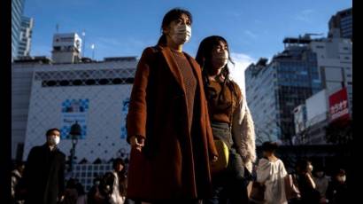 Personas con máscaras protectoras en el distrito comercial de Shibuya,  Japón