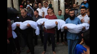 Familiares llevan los cuerpos de niños fallecidos tras bombardeos israelíes
