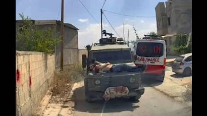 Herido y detenido este joven palestino es llevado sobre el capo de un vehículo militar israelí en Jenin.