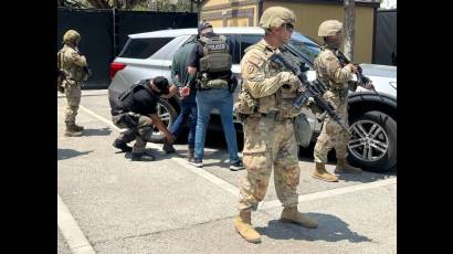 Miembros de la Guardia Nacional custodian a agentes del Servicio de Inmigración y Control de Aduanas