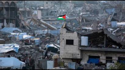 Una bandera palestina ondea entre las ruinas de edificios en el norte de Gaza