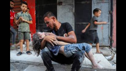 Padre palestino llora a su hijo muerto durante un bombardeo israelí