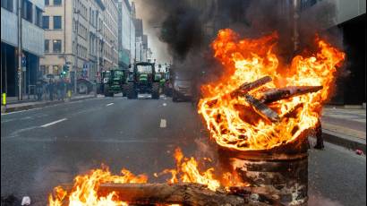 Barril ardiendo mientras agricultores europeos bloquean una carretera con sus tractores durante una protesta frente al Parlamento Europeo. Bruselas, 18 de diciembre de 2025.