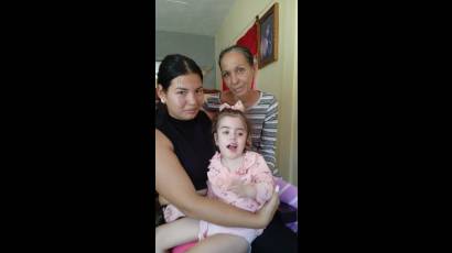 Natalia en las piernas de su mamá Gretel. Al lado del sillón, la abuela Idalmis.