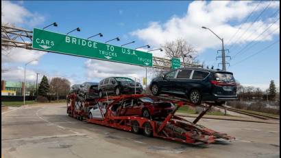 Un camión con vehículos se dispone a cruzar el puente Ambassador desde Canadá a Estados Unidos.