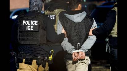 Agentes del Servicio de Inmigración y Control de Aduanas detienen a un hombre tras una redada en un complejo de apartamentos en Denver, Colorado.