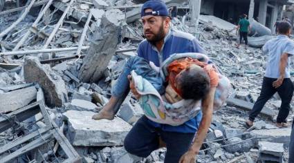 Un palestino lleva a un niño herido tras los ataques israelíes contra casas en Rafah, en el sur de la Franja de Gaza