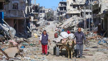 Palestinos caminan entre los escombros de la ciudad de Jan Yunis, en el sur de la Franja de Gaza, el 8 de marzo de 2024.