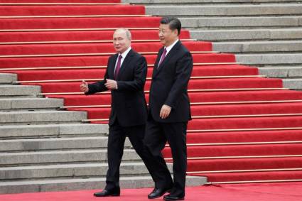 Xi Jinping y Vladímir Putin caminan juntos por la alfombra roja