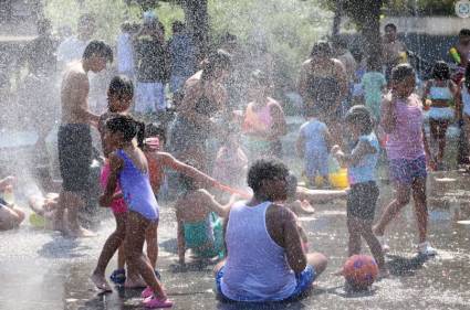 Transeúntes se refrescan bajo las fuentes del área recreativa Madrid Río