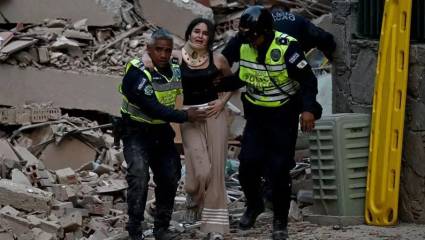 Policías socorren a una mujer entre los escombros de un edificio derrumbado en Caracas.