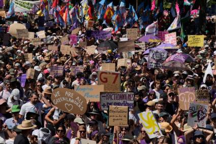 Los manifestantes sostienen carteles y pancartas mientras participan en una manifestación contra el G7 en Ginebra, Suiza.