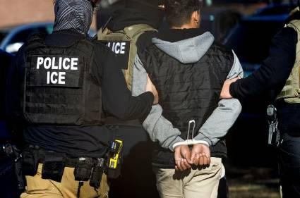 Agentes del Servicio de Inmigración y Control de Aduanas detienen a un hombre tras una redada en un complejo de apartamentos en Denver, Colorado.